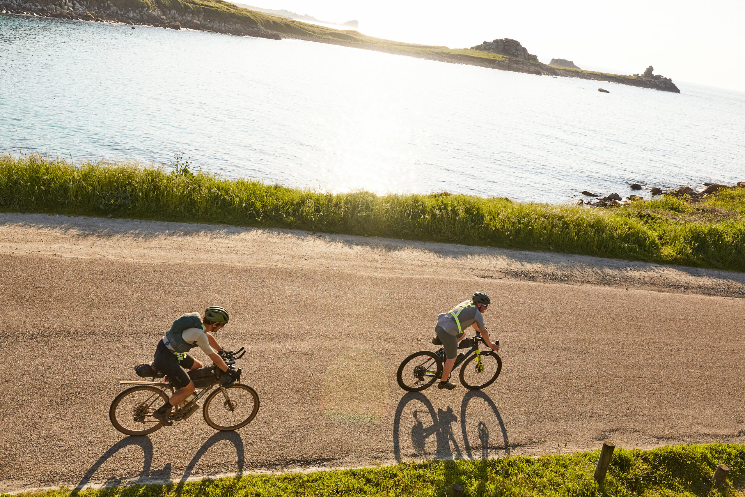 cyclistes sur une petite route bretonne le long du littoral au soleil couchant